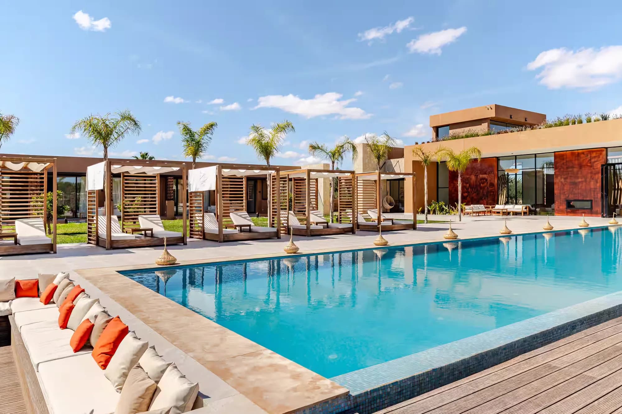 Het zwembad met loungebedden en cabana’s in de middagzon